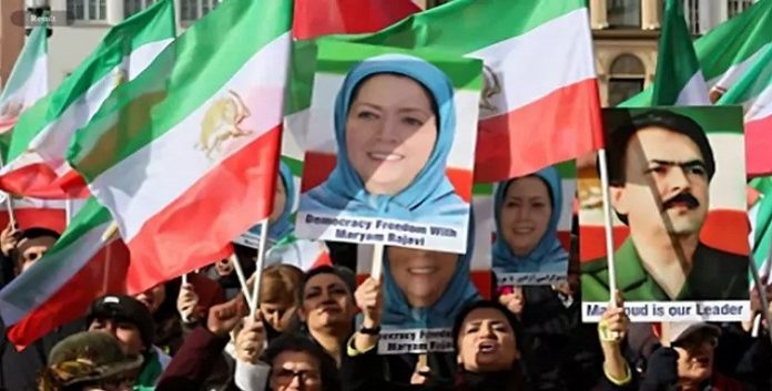 رويترز- أناس يرفعون العلم الايراني وصور زعيمة المعارضة الإيرانية مريم رجوي