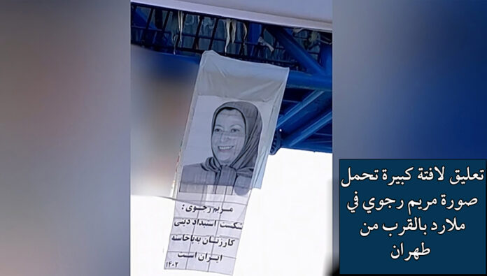 عشية اليوم العالمي للمرأة، تعليق لافتة كبيرة تحمل صورة مريم رجوي في ملارد بالقرب من طهران