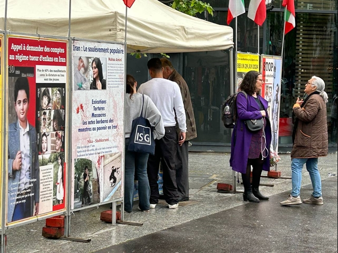 تکریماً لشهداء الانتفاضة الإيرانية طاولة كتب ومعرض لصورالشهداء فی باریس -تقریر مصور