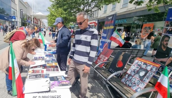 احیائاً لذكرى شهداء الانتفاضة الإيرانية طاولة كتب ومعرض صور للشهداء في ساوث هامبتون المملكة المتحدة