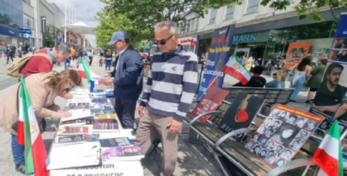 احیائاً لذكرى شهداء الانتفاضة الإيرانية طاولة كتب ومعرض صور للشهداء في ساوث هامبتون المملكة المتحدة