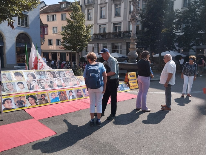 تضامنا مع الانتفاضة الوطنية الایرانیة طاولة كتب ومعرض لصور الشهداء في مدینة زيورخ، سويسرا